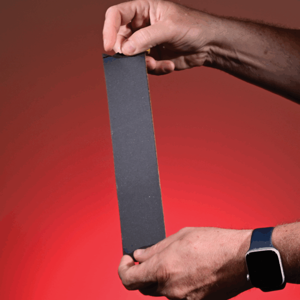 Close-up of the smooth, black front side of a piece of scrim foam tape.
