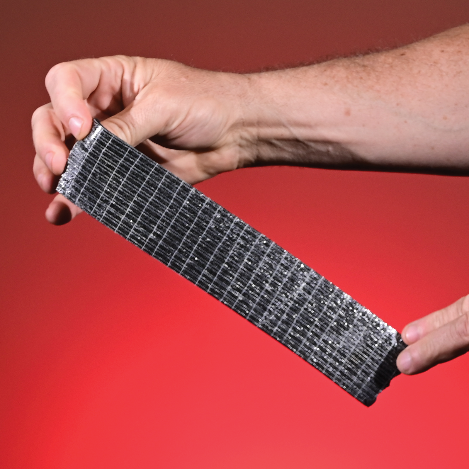 Extreme close-up of the woven scrim reinforcement visible in the adhesive layer of the foam tape
