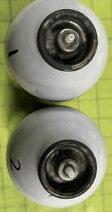 A close-up photo of an aerosol can's metal cup showing corrosion and discoloration.