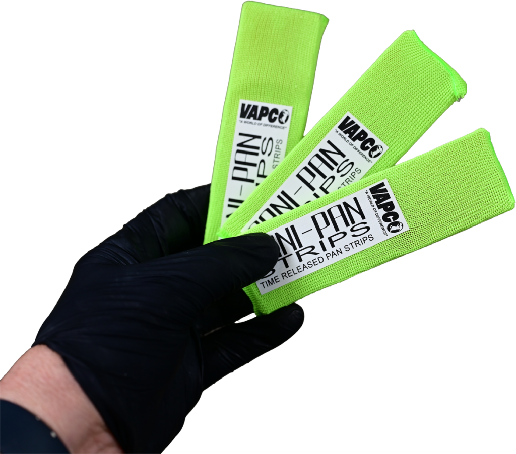 A hand in a black glove holds three Vapco Sani Pan Strips to prevent HVAC drain clogs.